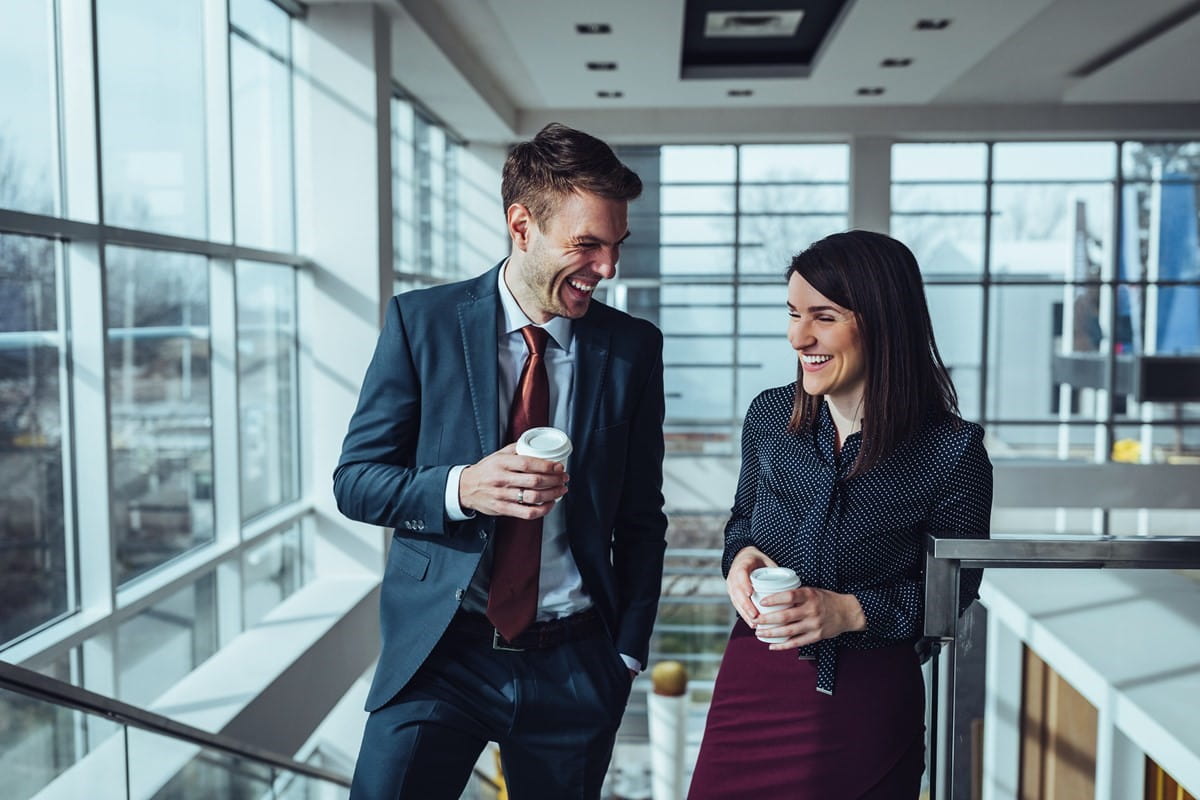 Two people in an office laughing